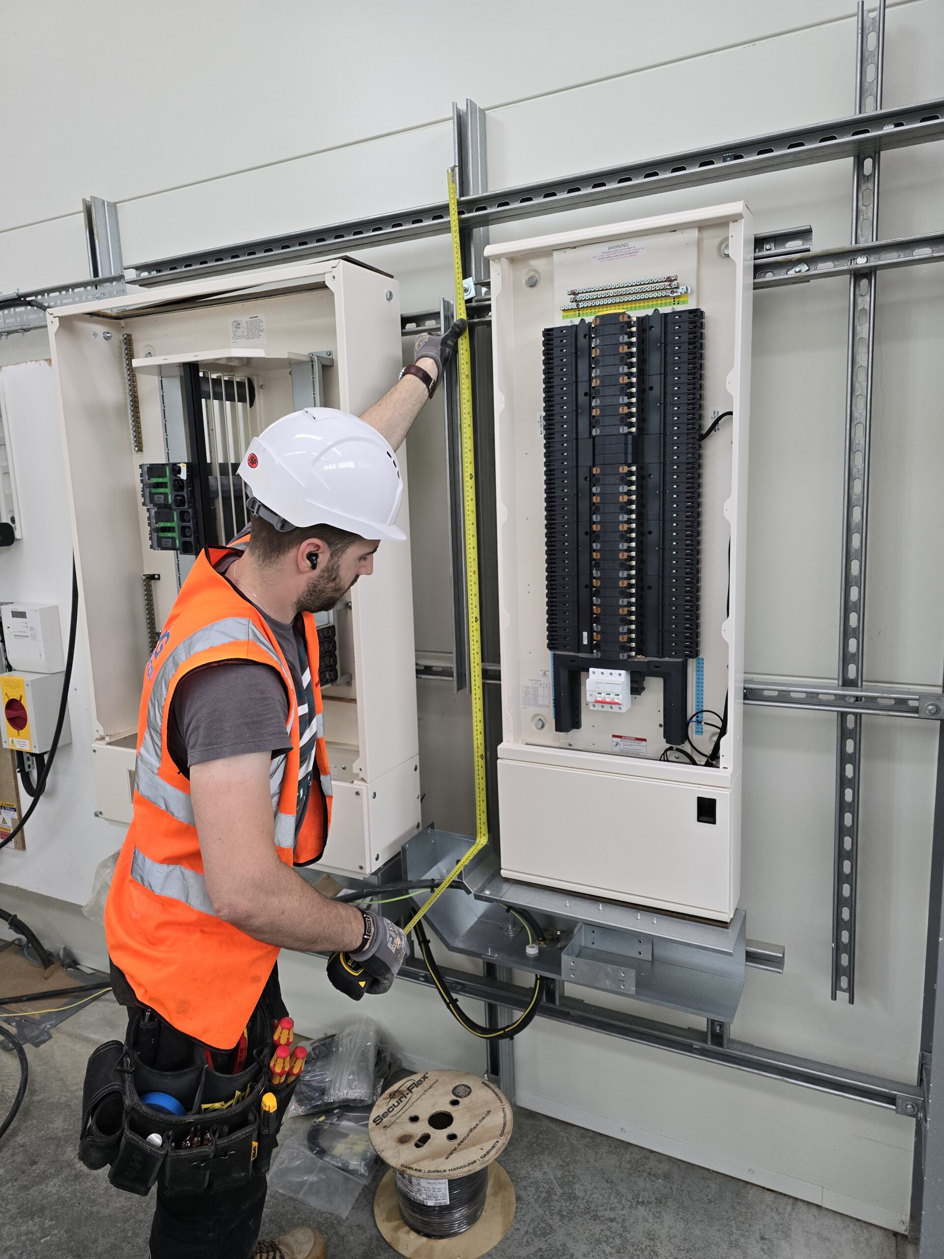 Electrician working on a commercial distribution board installation for CAG Electrical Ltd
